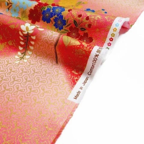 Peachy pink Japanese fabric edge decorated with small gold geometrics and flowers