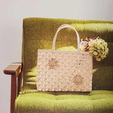 Beige paper basketry handbag on a green sofa